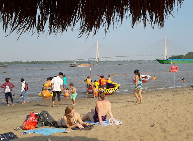 Du khách nước ngoài trên bãi cát sông Hậu - Ảnh: Phương Nguyên.